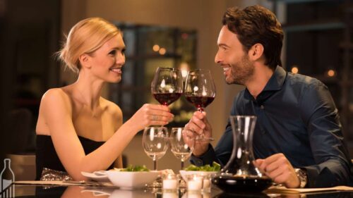 Casal brindando com vinho em jantar romântico de Dia dos Namorados